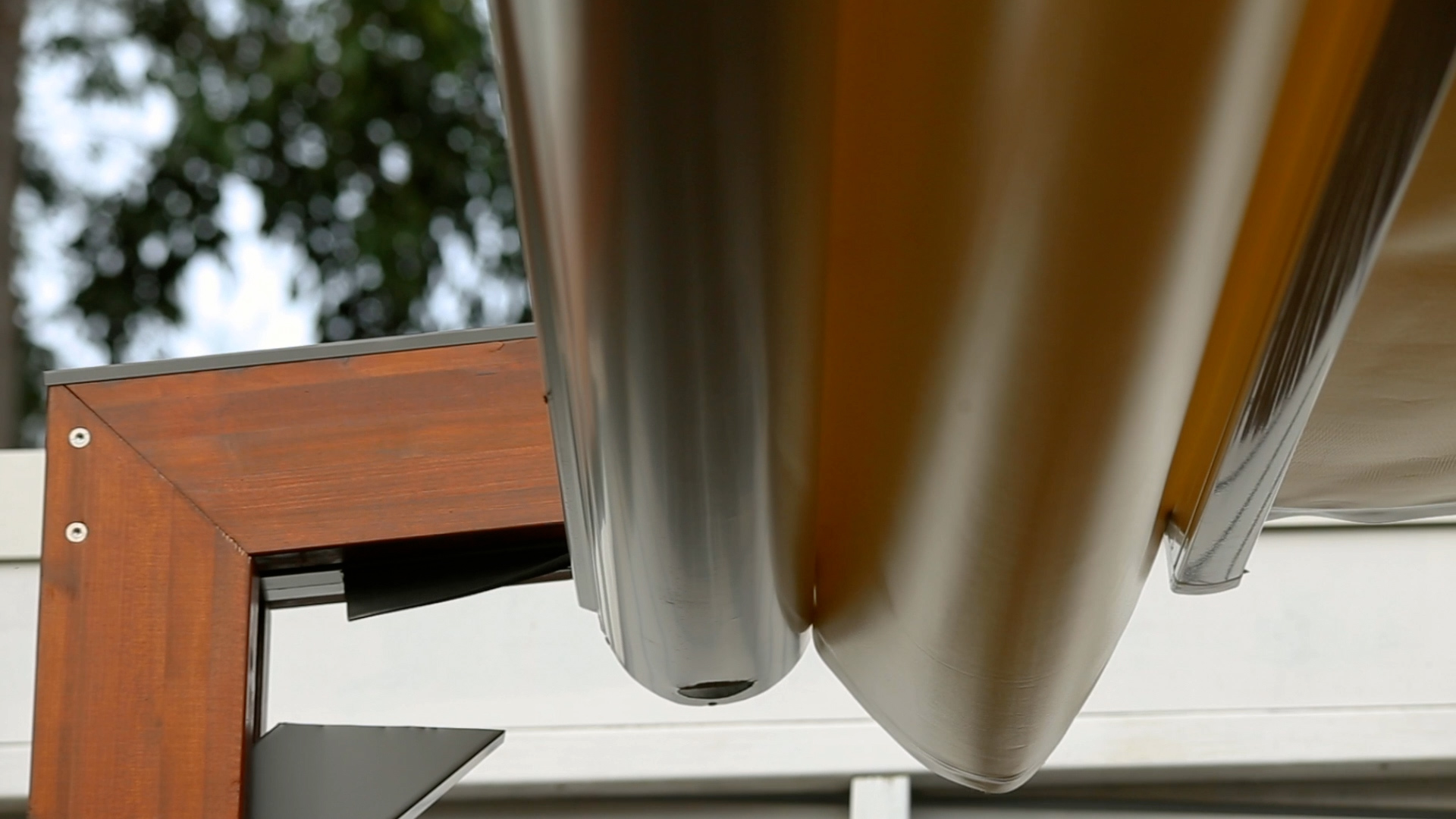Close-up of the Duet retractable gutter attached to the front of the roof fabric